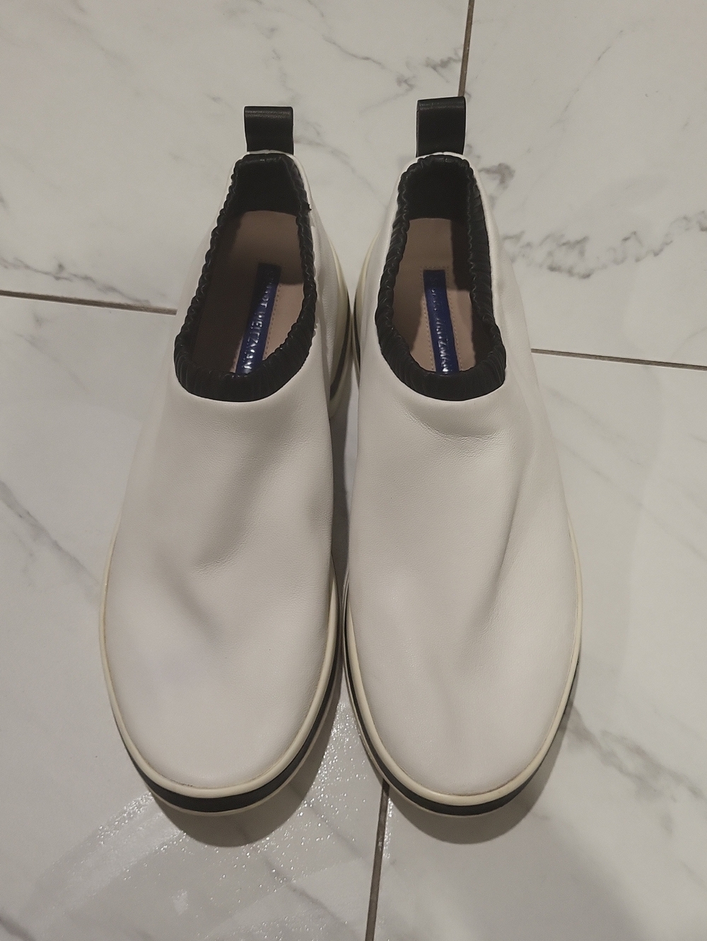 The SW-612 Sneaker Stuart Weitzman White Slip-On Leather Loafers with Black Trim